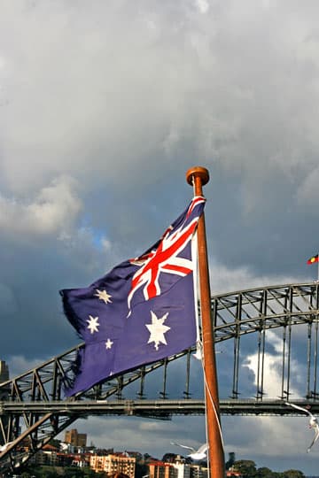 People overlooking Sydney Harbour Bridge with Australian flag